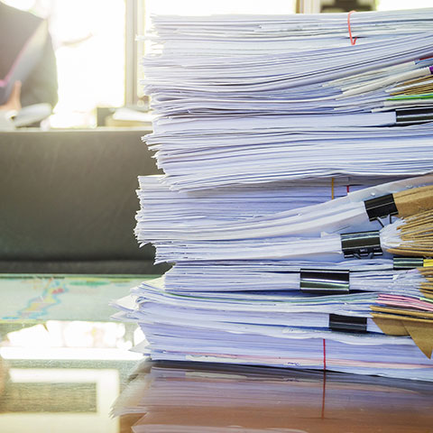 Pile de dossiers papier sur un bureau