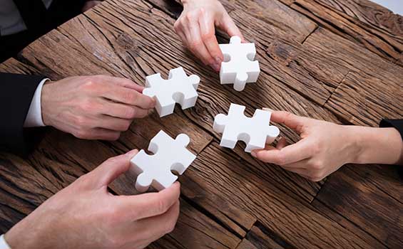 Businesspeople putting together puzzle pieces