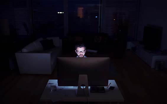 Man on his computer in the dark