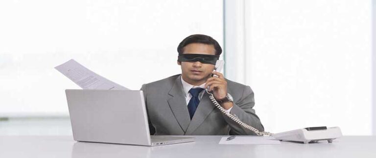 Blindfolded businessman working making a blind sales call
