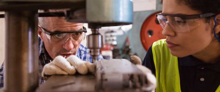 Older factory worker teaching a younger employee - Is Your Expert Knowledge Retiring? CPQ Bridges the Experience Gap