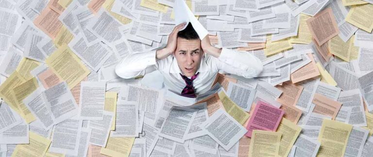 Man in pile of paper - Paper-to-Digital Dilemma: Communications to Move, Channels to Prioritize